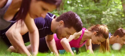 Gruppe macht Fitnessübungen im Park