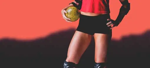 Athletiktraining im Handball | Weibliche Sportler mit Ellenbogen-Pad, die Handball auf unscharfen Bergen halten